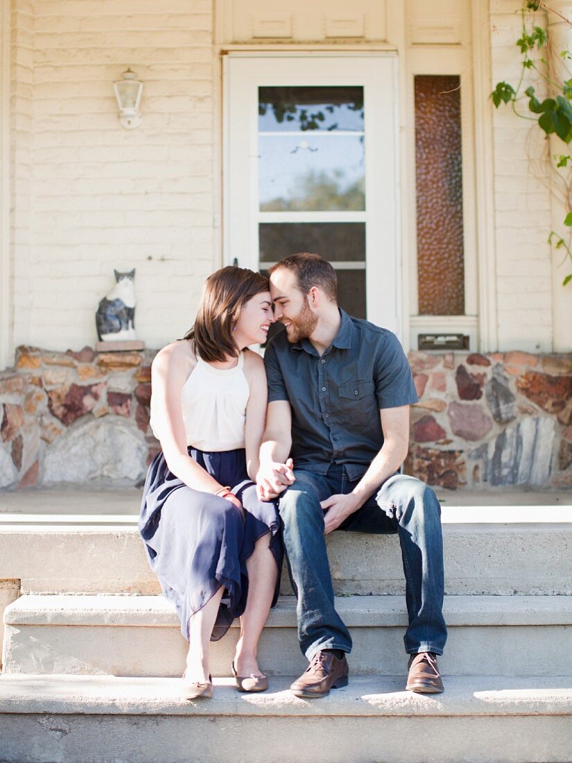 Happy young couple in front of house