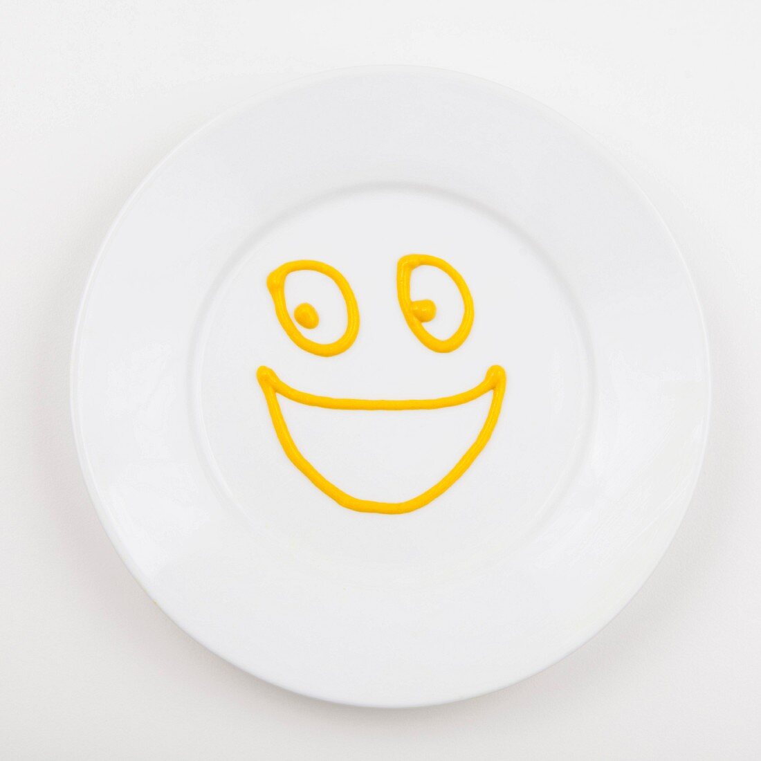 Plate with smiley face made of mustard