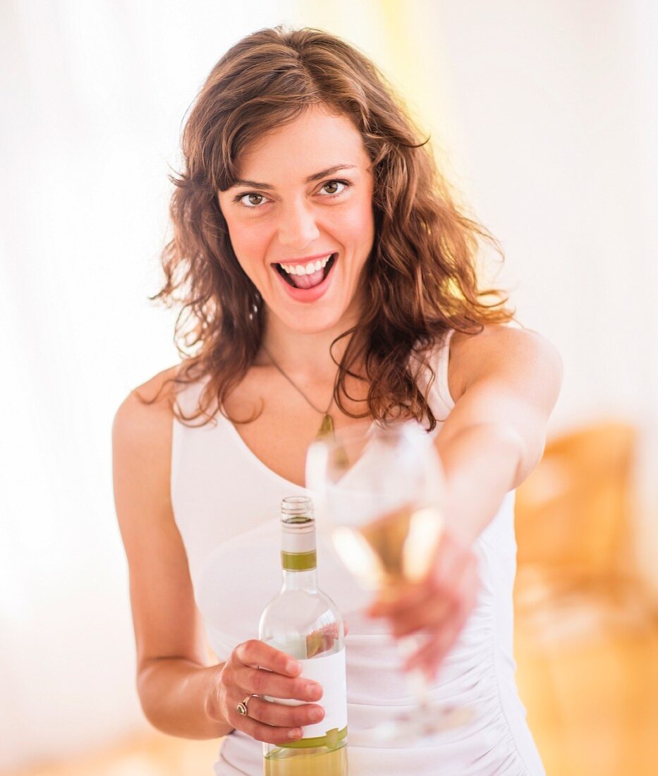Frau hält Weinflasche und Glas
