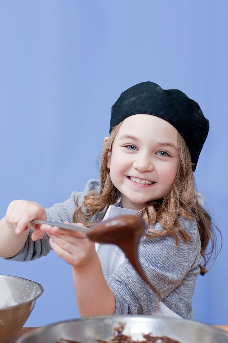 Young girl holding a mixing spoon