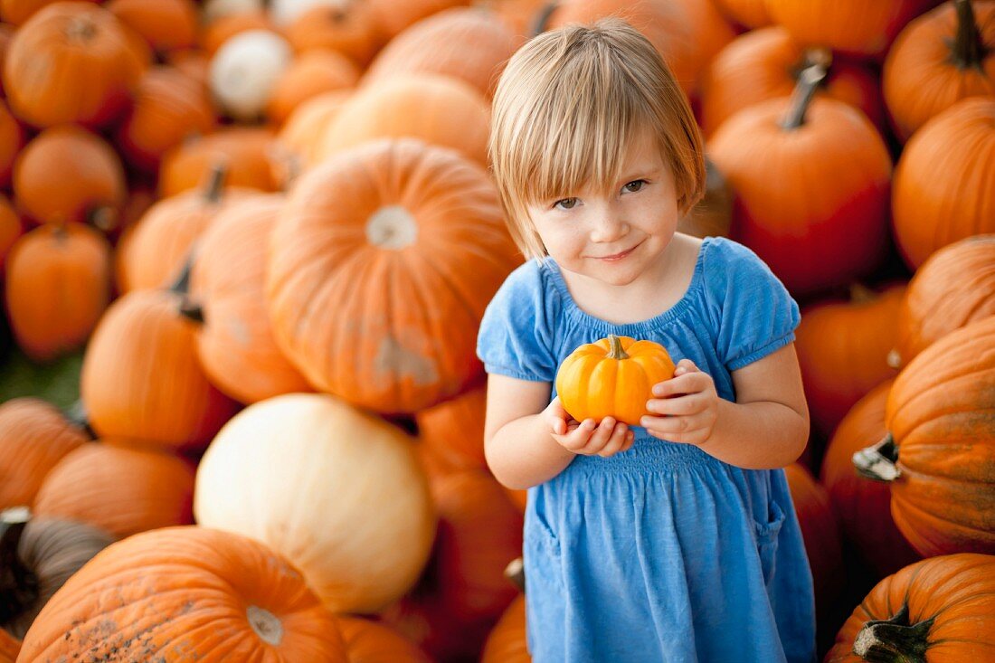 USA, Utah, Orem, portrait of girl (2-3) holding pumpkin