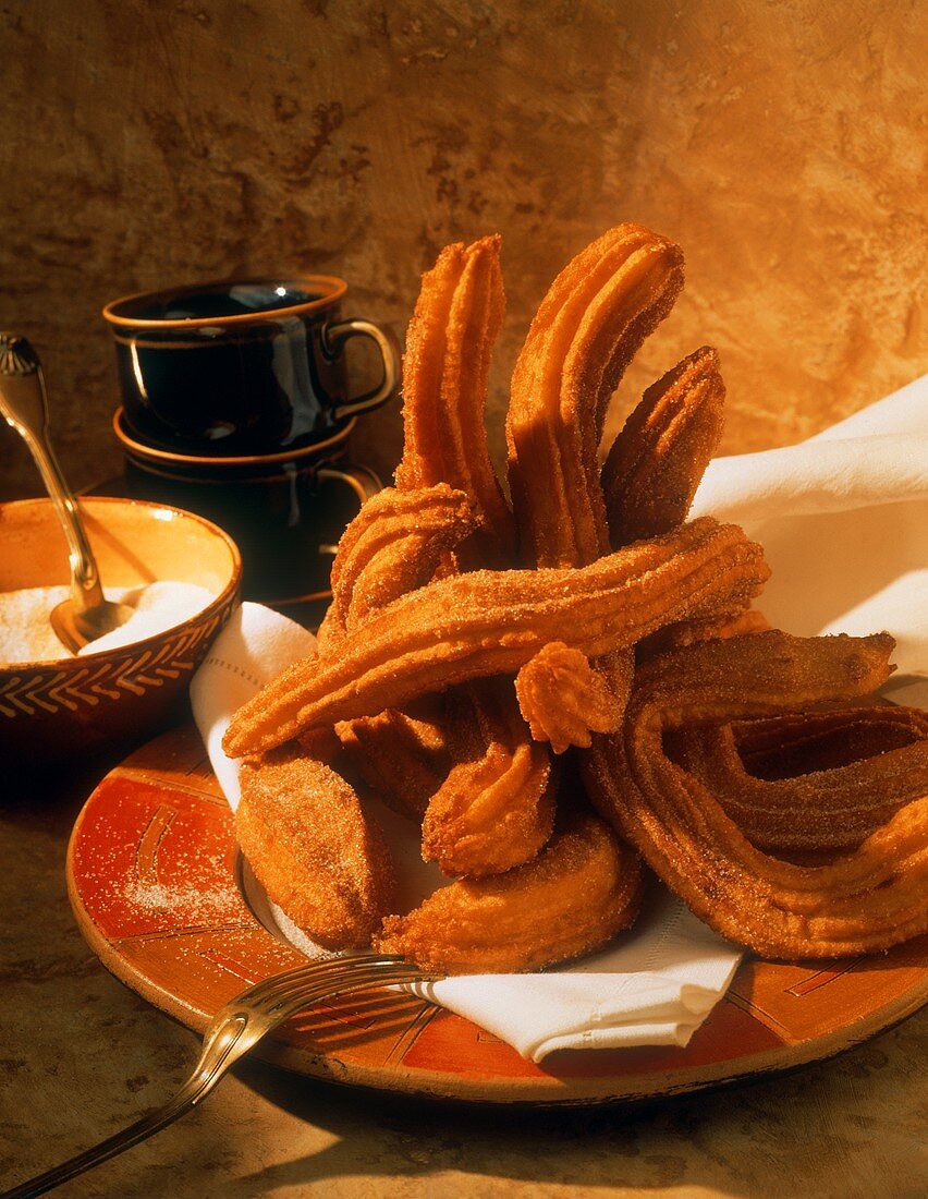 Spritzkuchen (Churros) auf Teller gestapelt