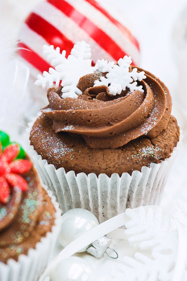 Chocolate cupcakes decorated with sugar flowers and snow flakes for Christmas