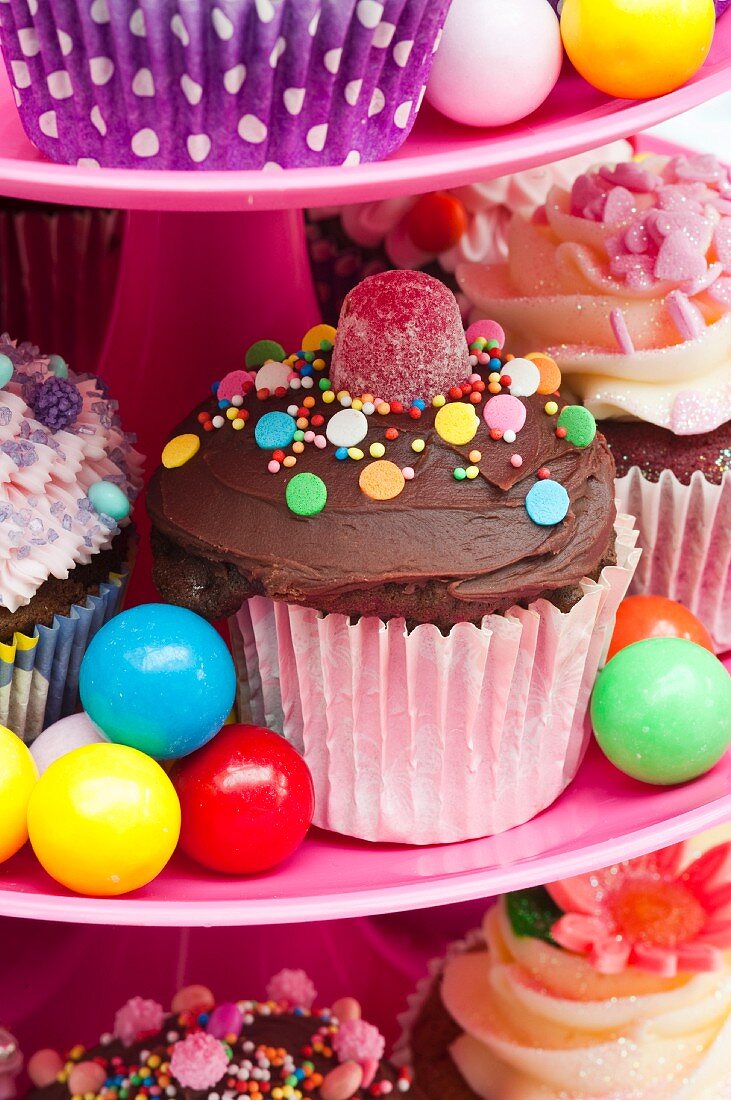 Bunte Cupcakes und Süssigkeiten für eine Party auf einer Etagere