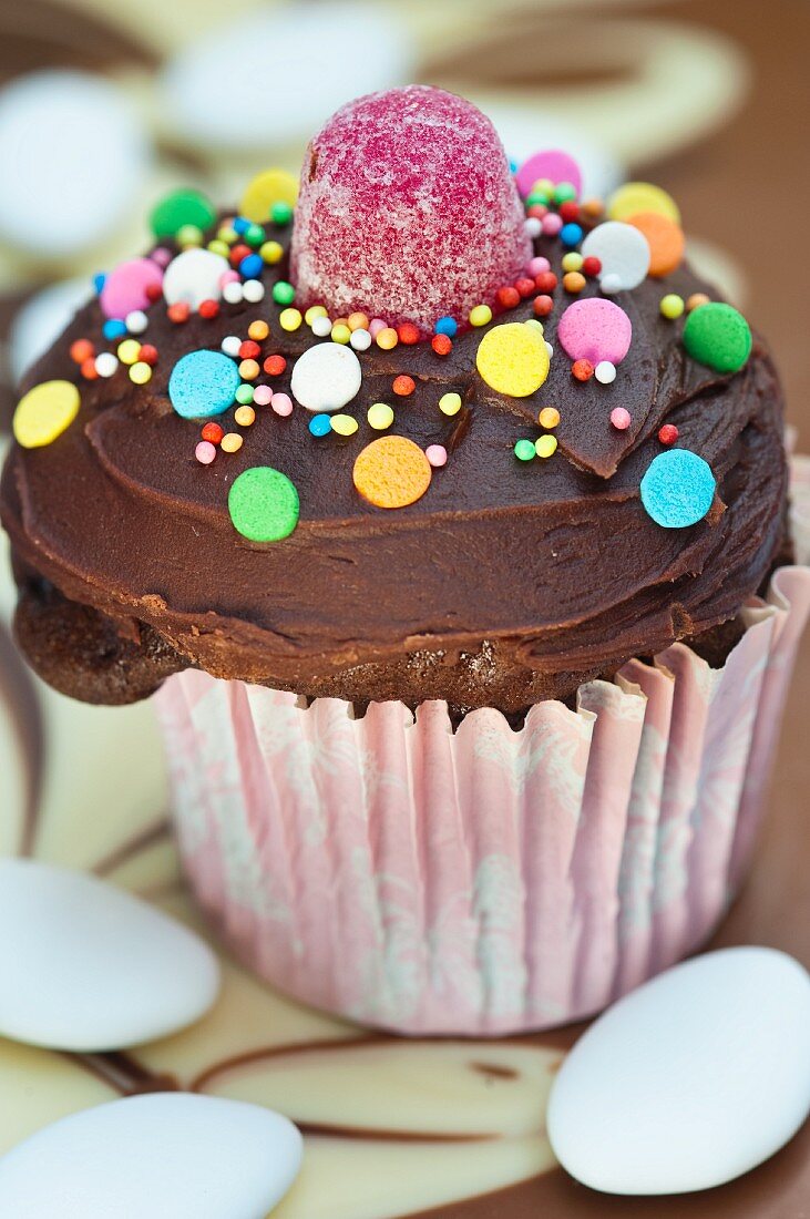Schokoladencupcake mit bunten Süssigkeiten