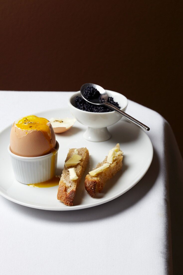 Weichgekochtes Ei mit Kaviar und Butterbrot