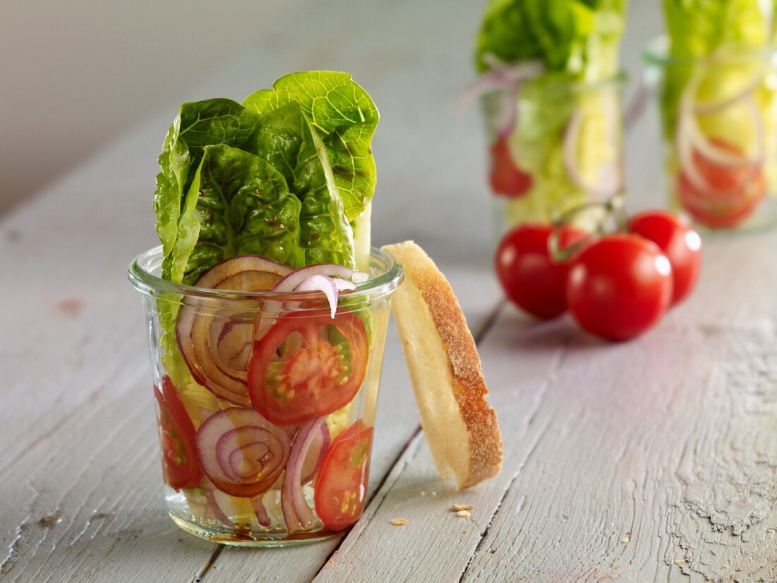 Romaine lettuce with red onion and tomatoes in glasses