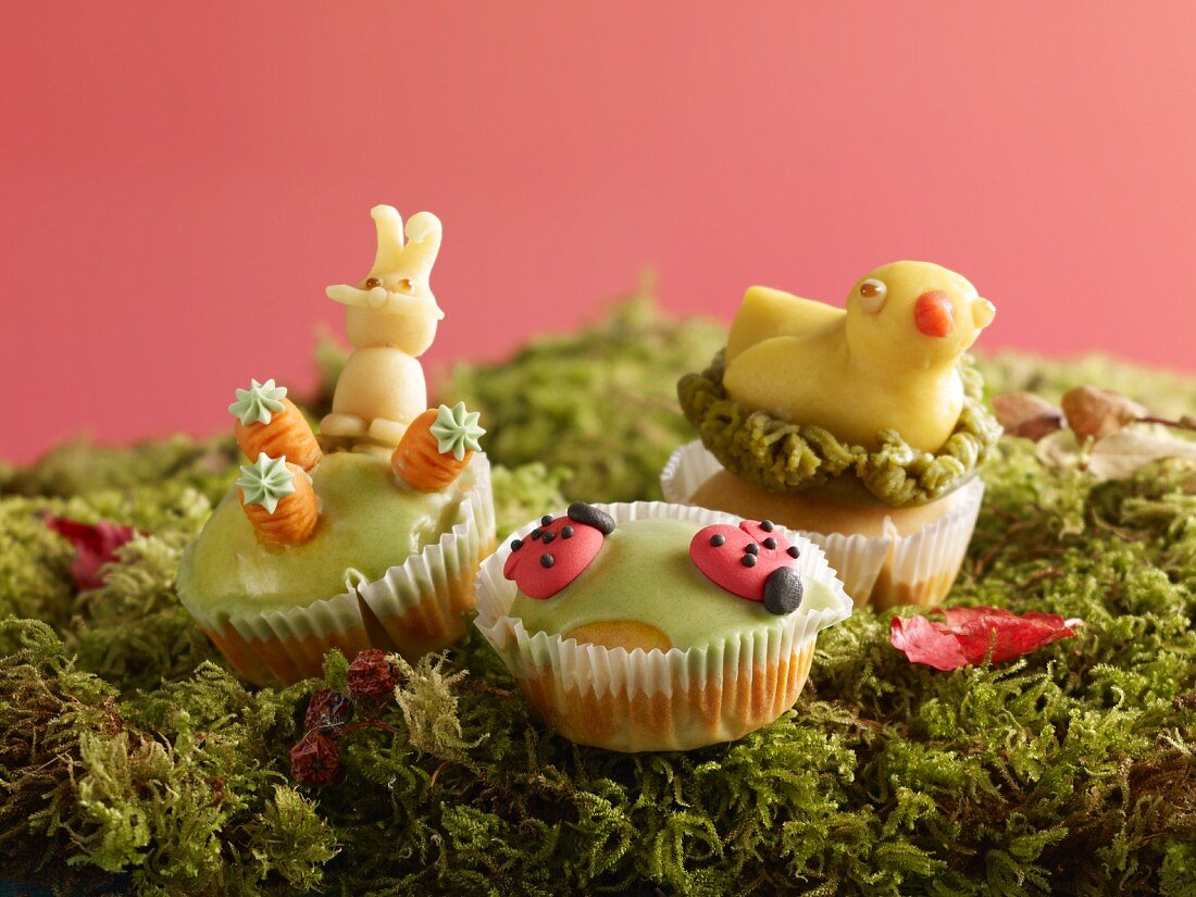 Muffins with marzipan decorations for Easter on moss