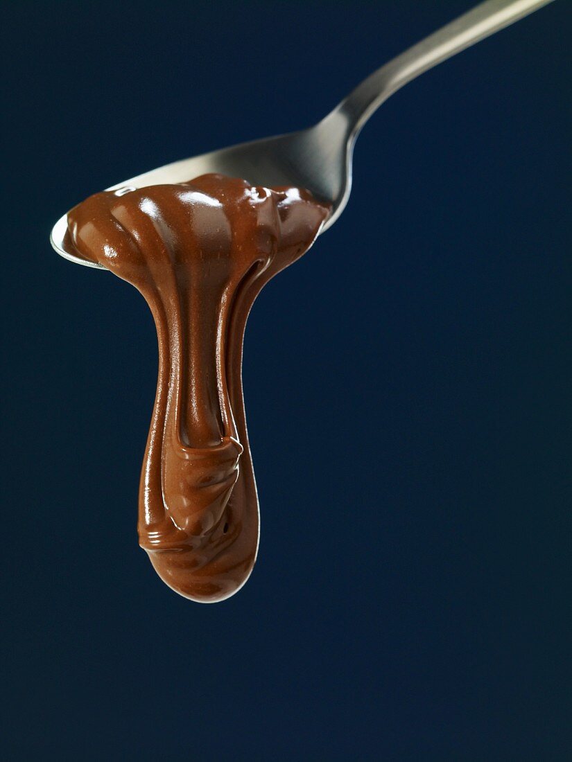 Schokolade fliesst vom Löffel