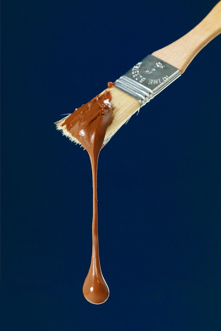 Geschmolzene Schokolade tropft vom Backpinsel