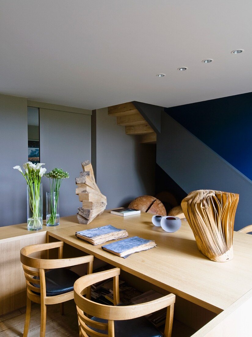 Interior with wooden table, armchairs & wooden sculpture