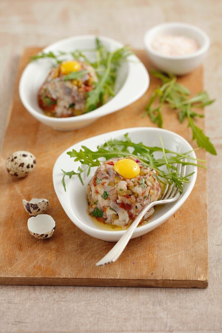 Herring tartare with dried tomatoes, pickled cucumbers and quail egg