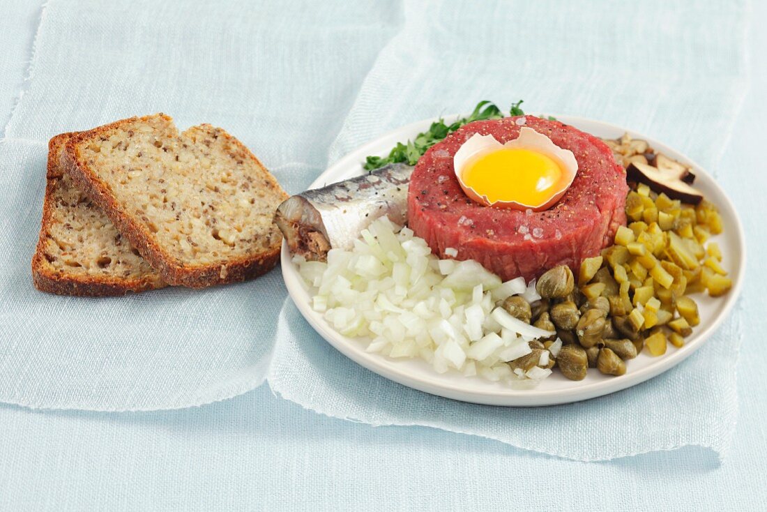 Klassisches Beef Tatar mit Ei, Zwiebeln, Gurken und Champignons