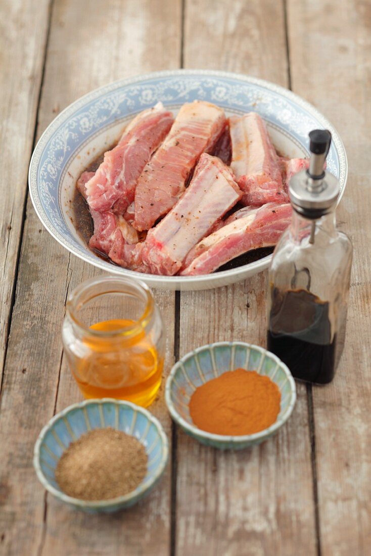 Pork ribs with ingredients for the marinade (honey, soy sauce, spices)