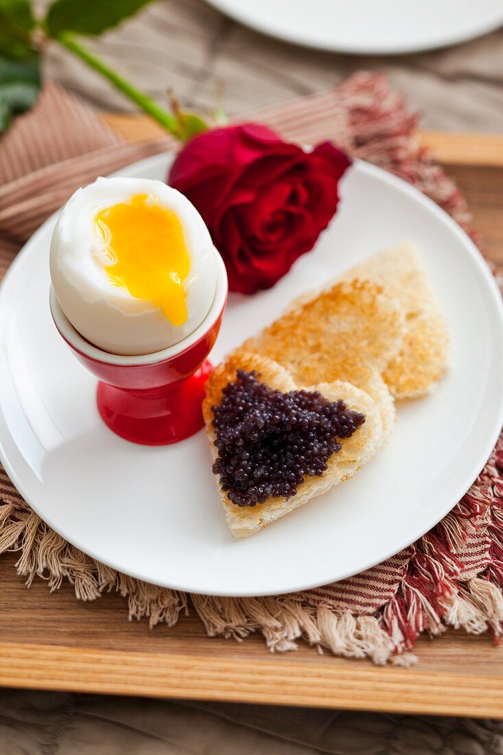 Soft boiled egg with caviar on toast 'hearts'