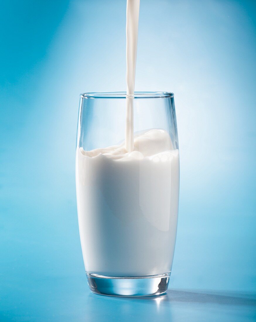 Milch fließt in ein Glas