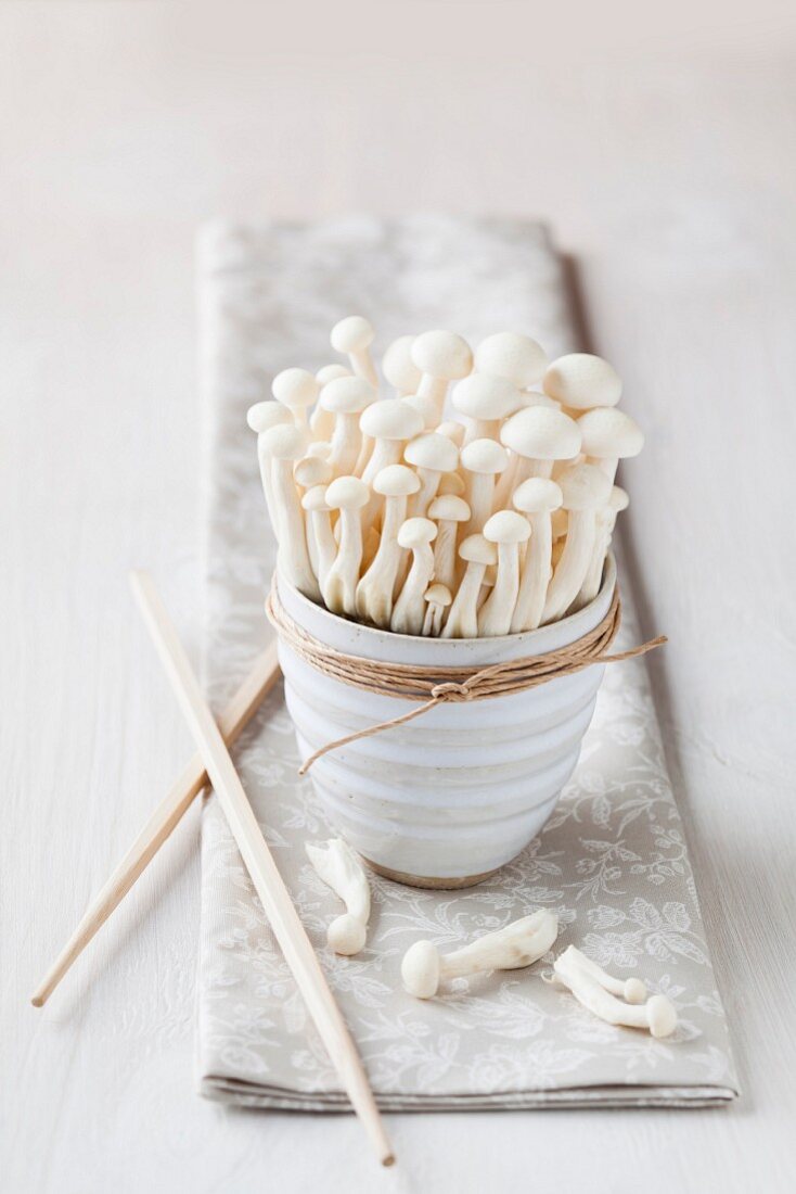 Shimeji Pilze in einer Schale mit Stäbchen auf Serviette