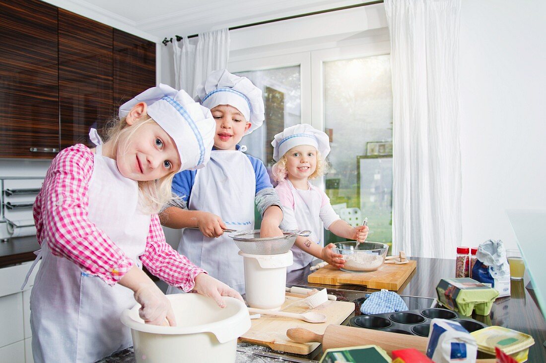 Mädchen und Junge bereiten Teig in der Küche zu