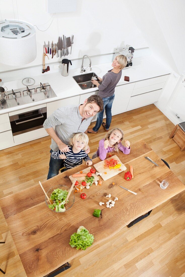 Eltern kochen zusammen mit den Kindern