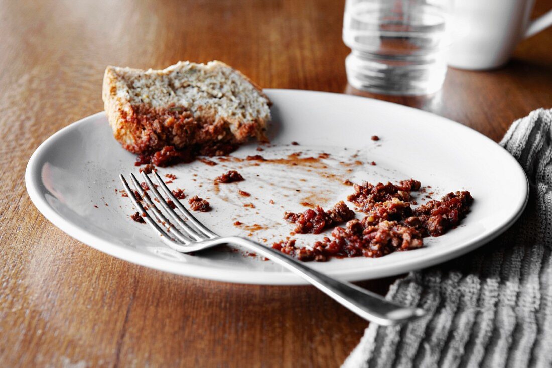 A plate with the remains of a meal and bread