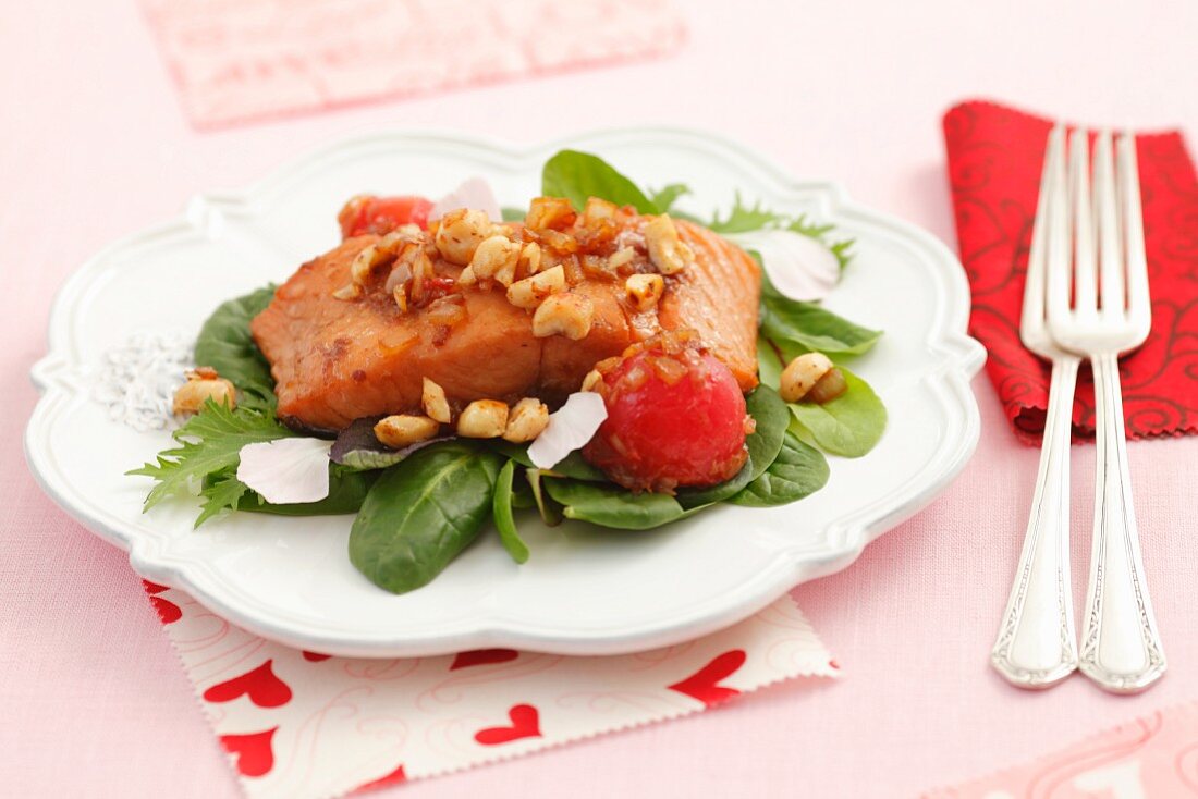 Roasted salmon fillets with shallots, cherry tomatoes, hazelnuts and petals