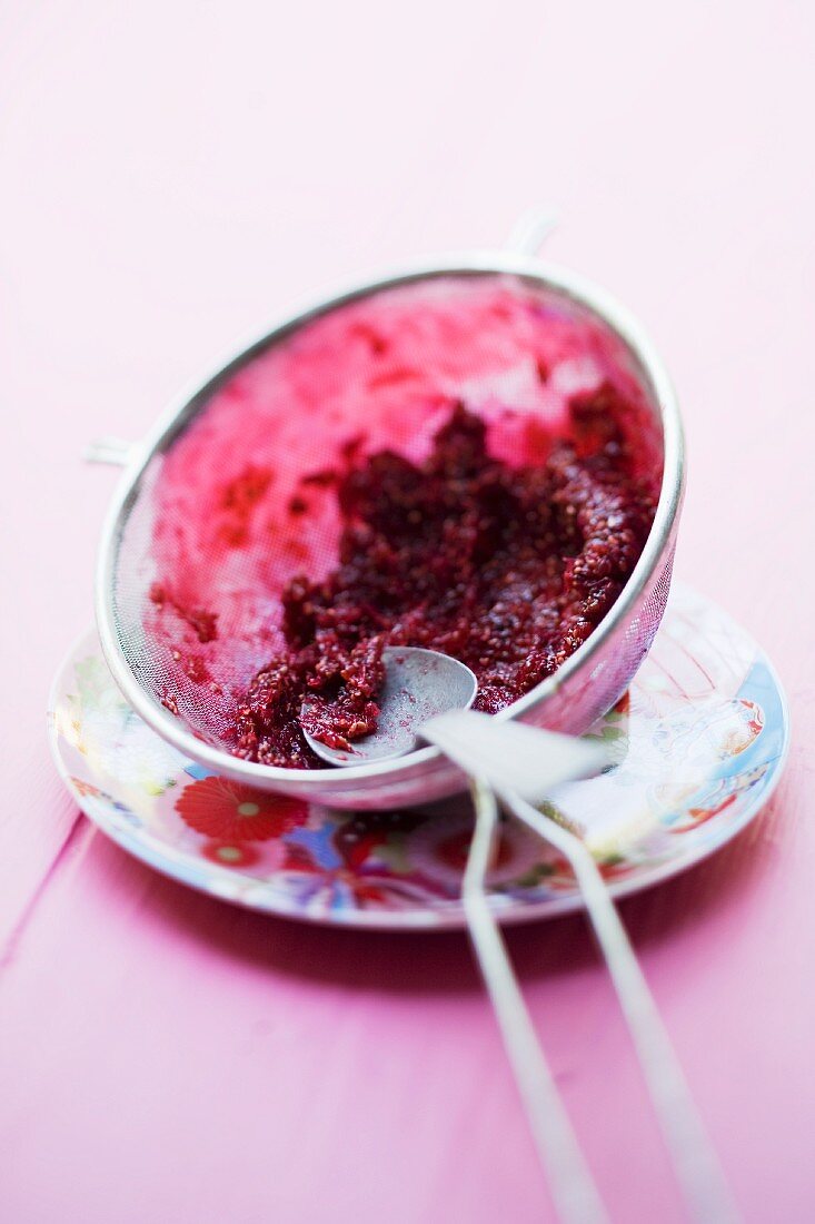 Straining red currants through a sieve