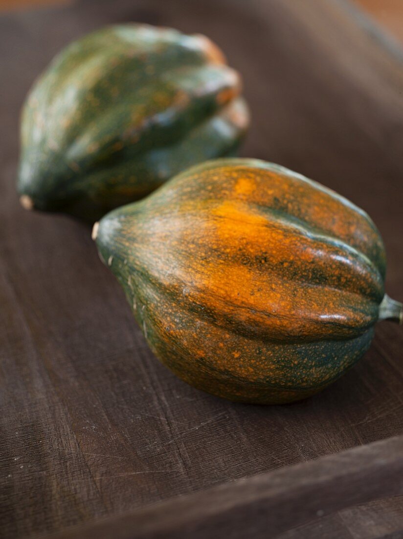 Two Whole Acorn Squash on a Wooden Tray