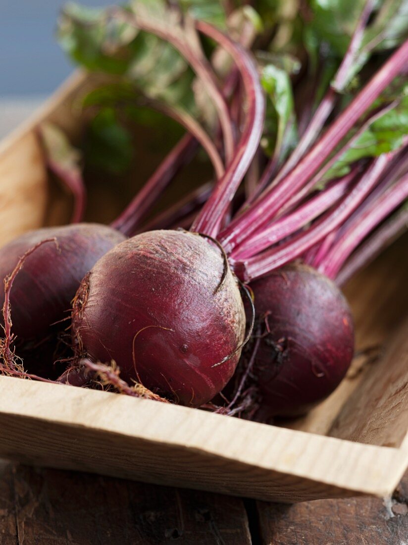 Whole Beets with Beet Greens in a Wooden Tray