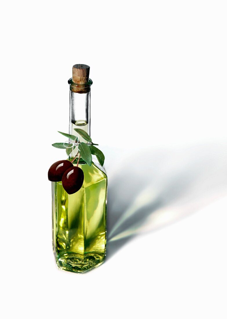 An olive oil bottle with black olives