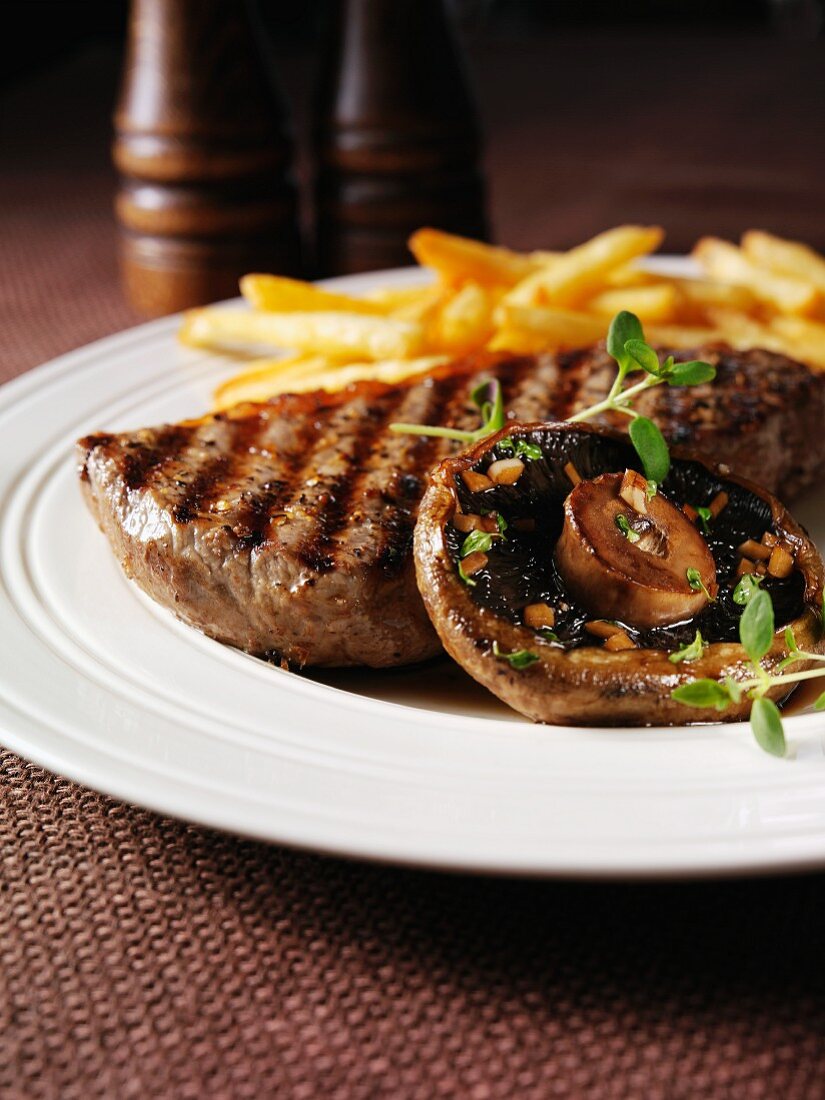 Beef steak with a portobello mushroom and chips