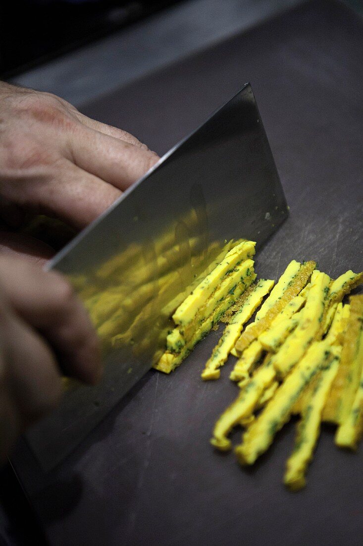 An omelette being sliced into strips