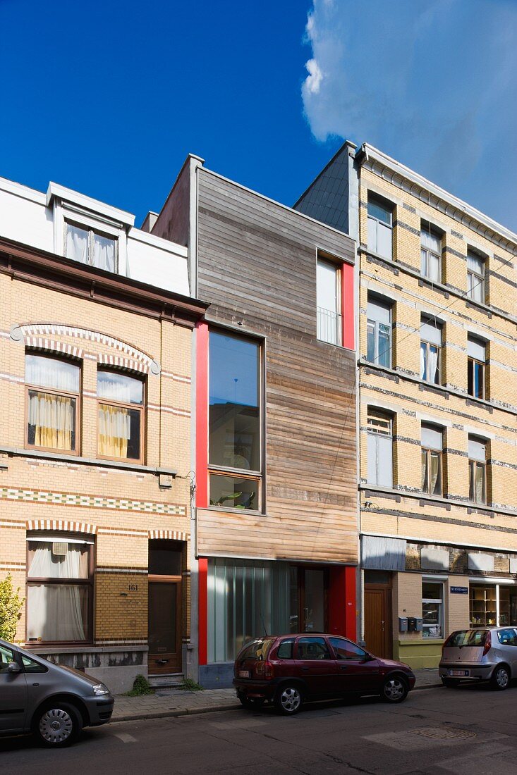 Blue sky above a town home with a cedar facade