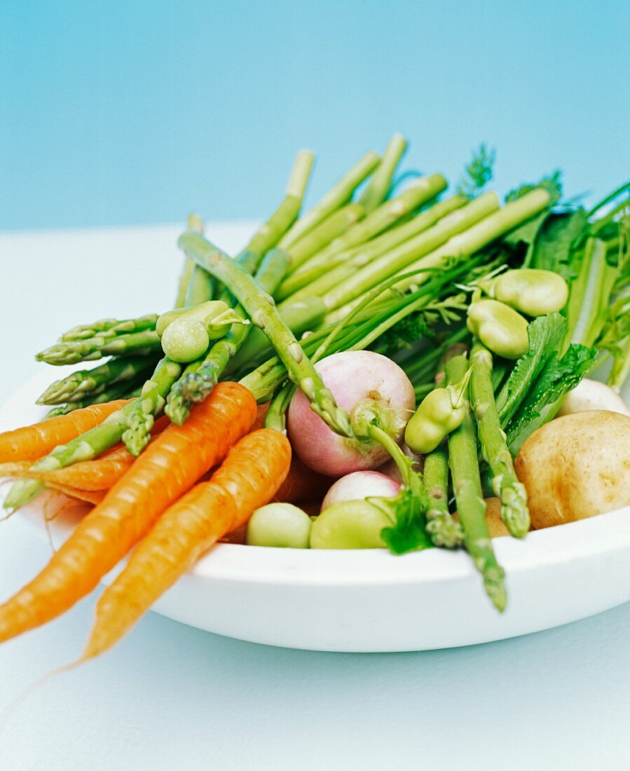 Nahaufnahme von einer Schüssel mit Frühlingsgemüse (Karotten, Bohnen, Spargel, Rüben und Kartoffeln)