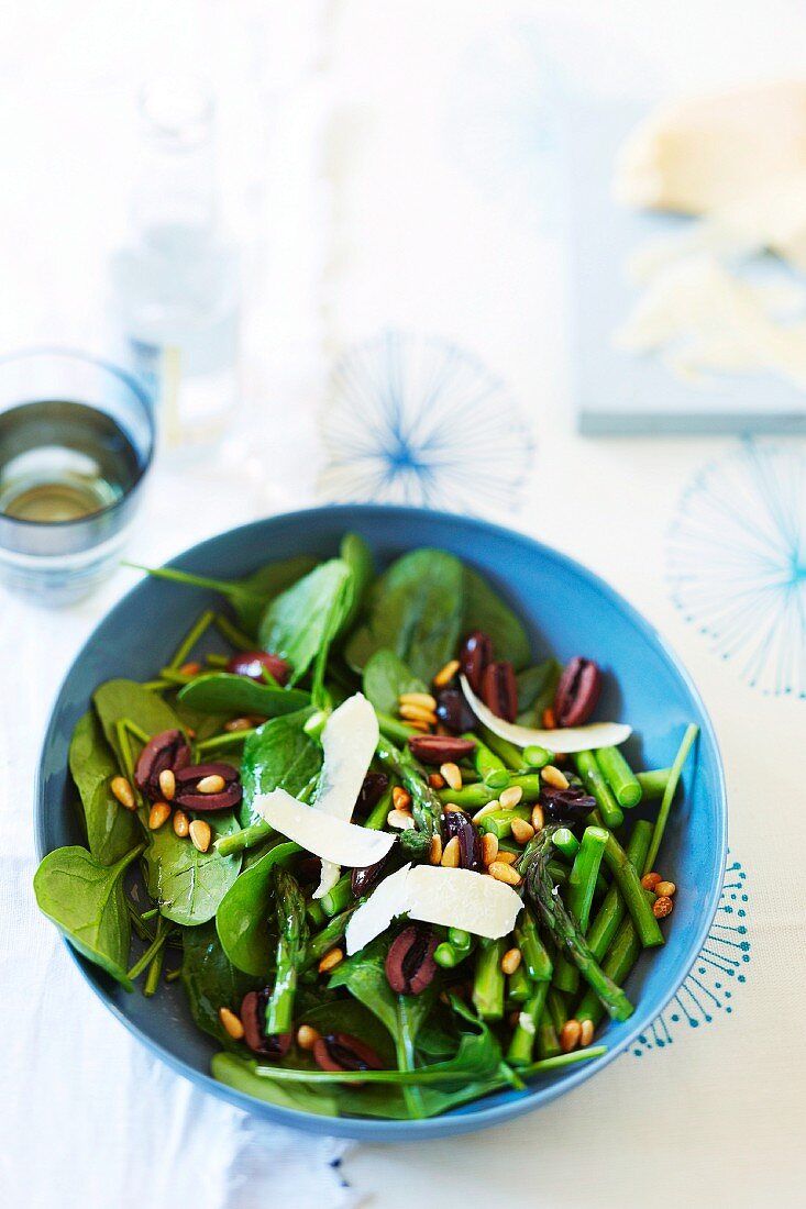 Salad with asparagus, baby spinach and pine nuts