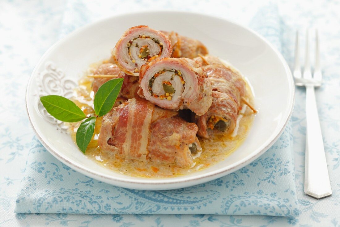 Rolled pork wrapped in bacon, with carrots, pickled gherkins and mustard