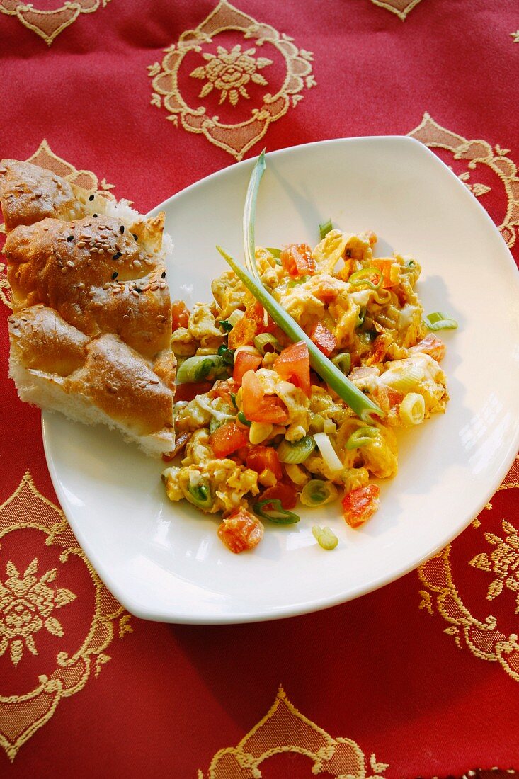 Indian scrambled egg with tomatoes, spring onions and flatbread
