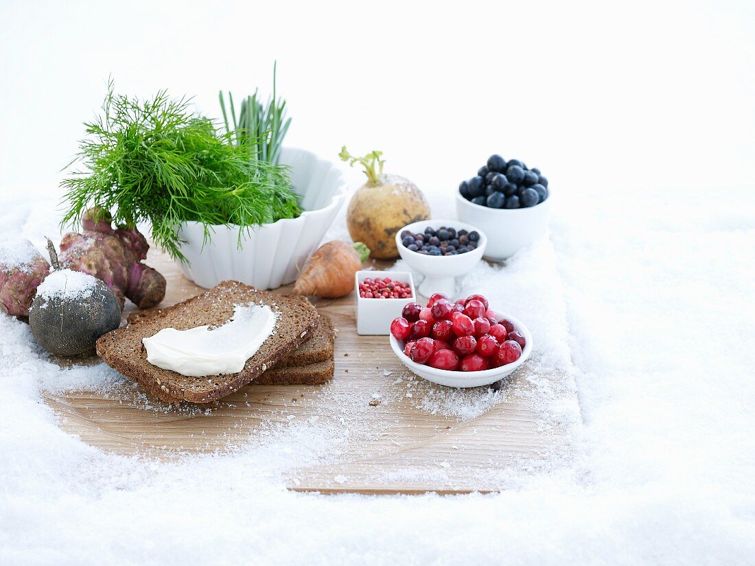 Stillleben mit Beeren, Vollkornbrot und Kräutern