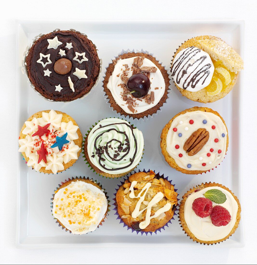 Assorted decorated cupcakes on a square plate