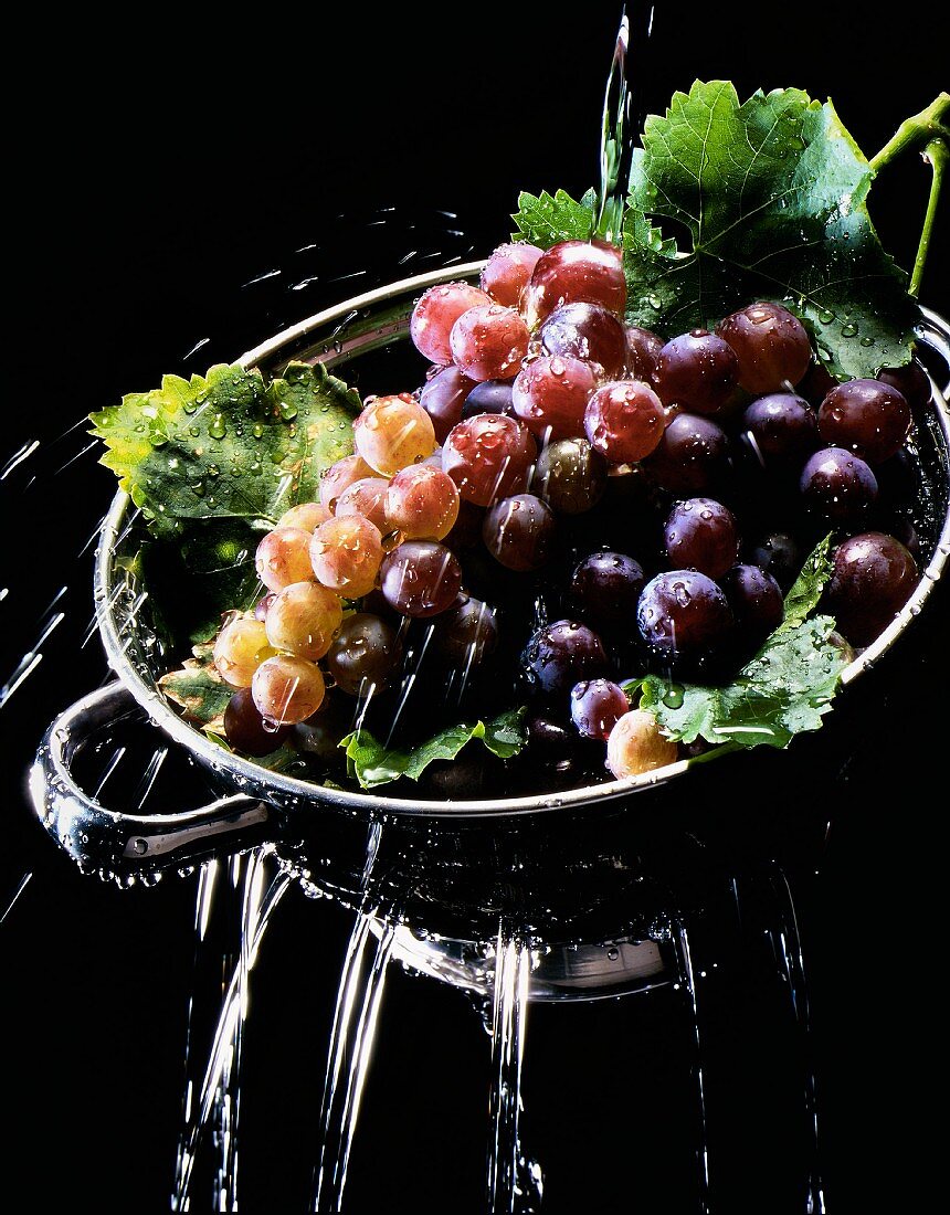 Grapes being washed in a sieve