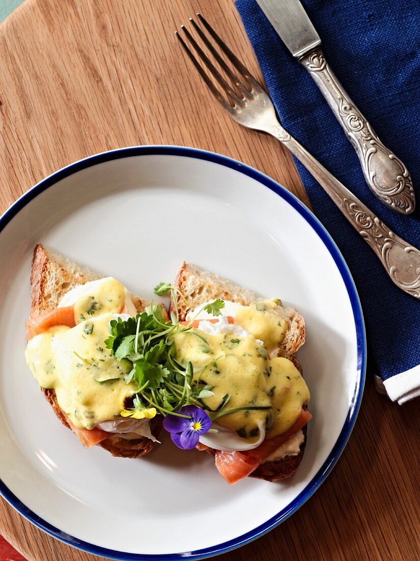 Toasted bread topped with a poached egg, salmon and hollandaise sauce