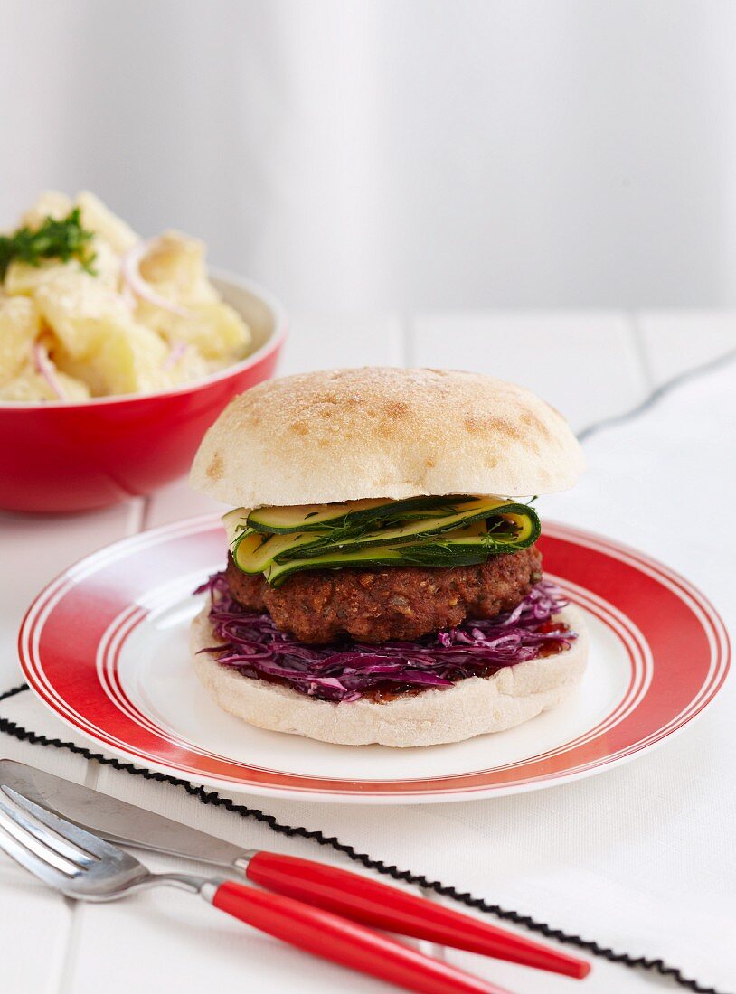 Turkey burger with red cabbage and courgette, served with potato salad