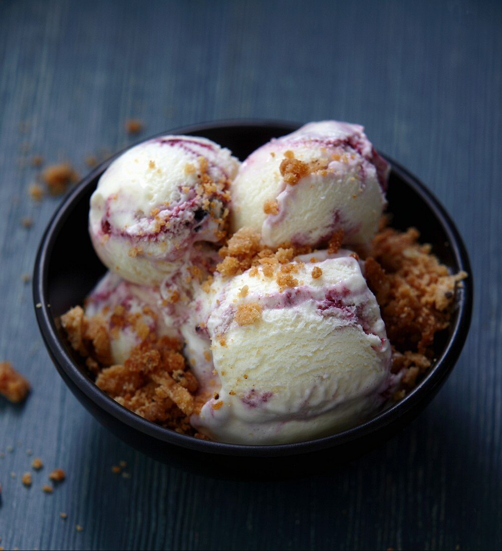 Several scoops of blackberry and blueberry ice cream sprinkled with crumble