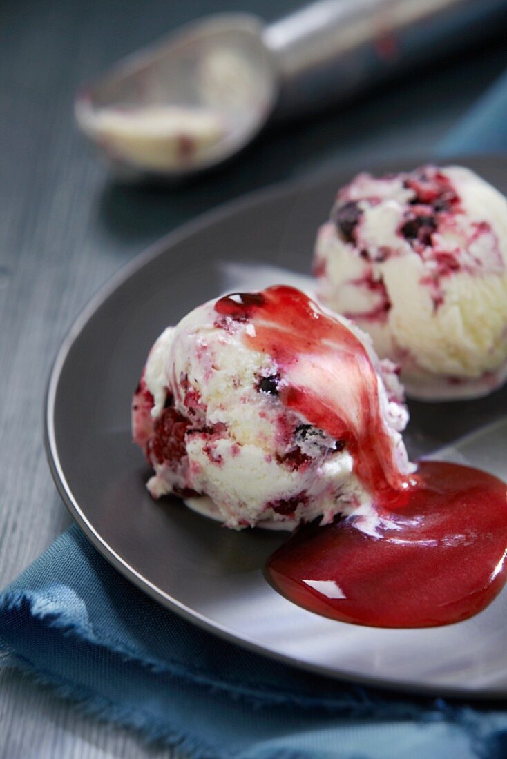 Zwei Kugeln Brombeer-Heidelbeer-Eis mit Fruchtsauce