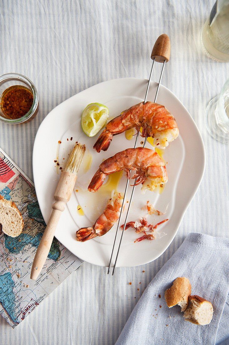 A king prawn skewer with bread and a map