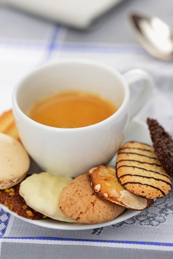 A cup of espresso with assorted biscuits