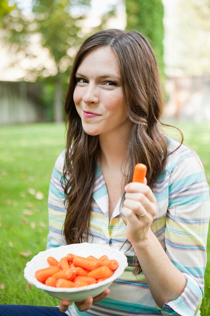 Junge Frau isst Karotten