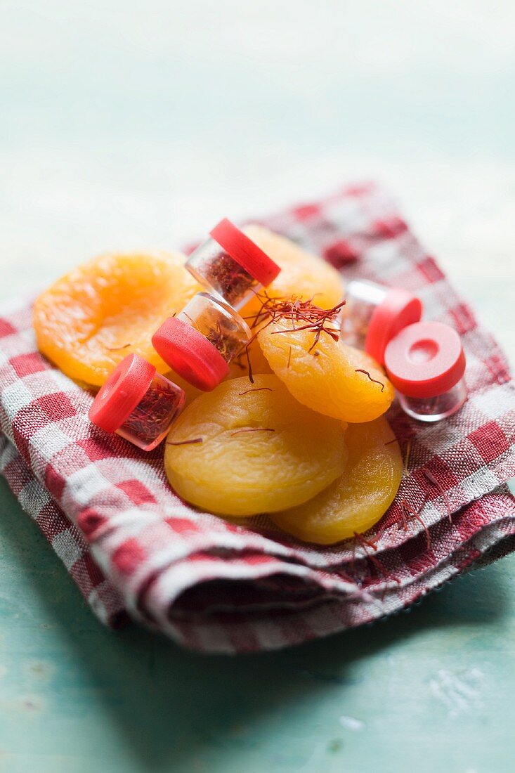 Dried apricots and saffron threads on a checked cloth