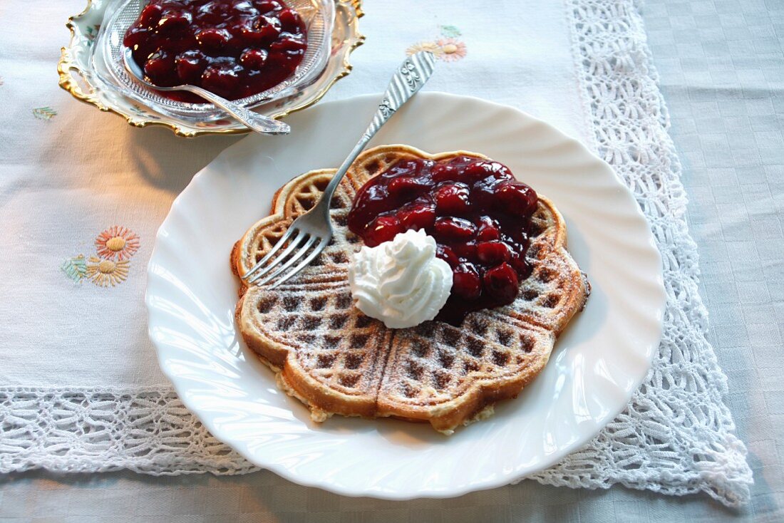 Waffles topped with cherry compote and cream