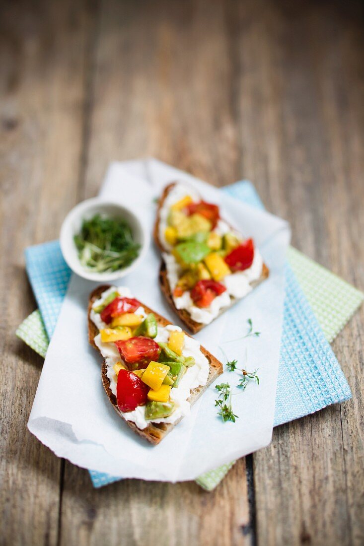 Rustic bread topped with avocado, mango, cherry tomatoes and cress