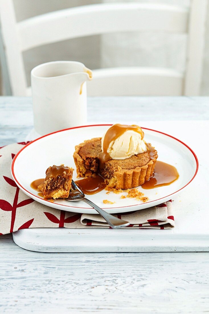 A mini date and pecan tart with caramel sauce